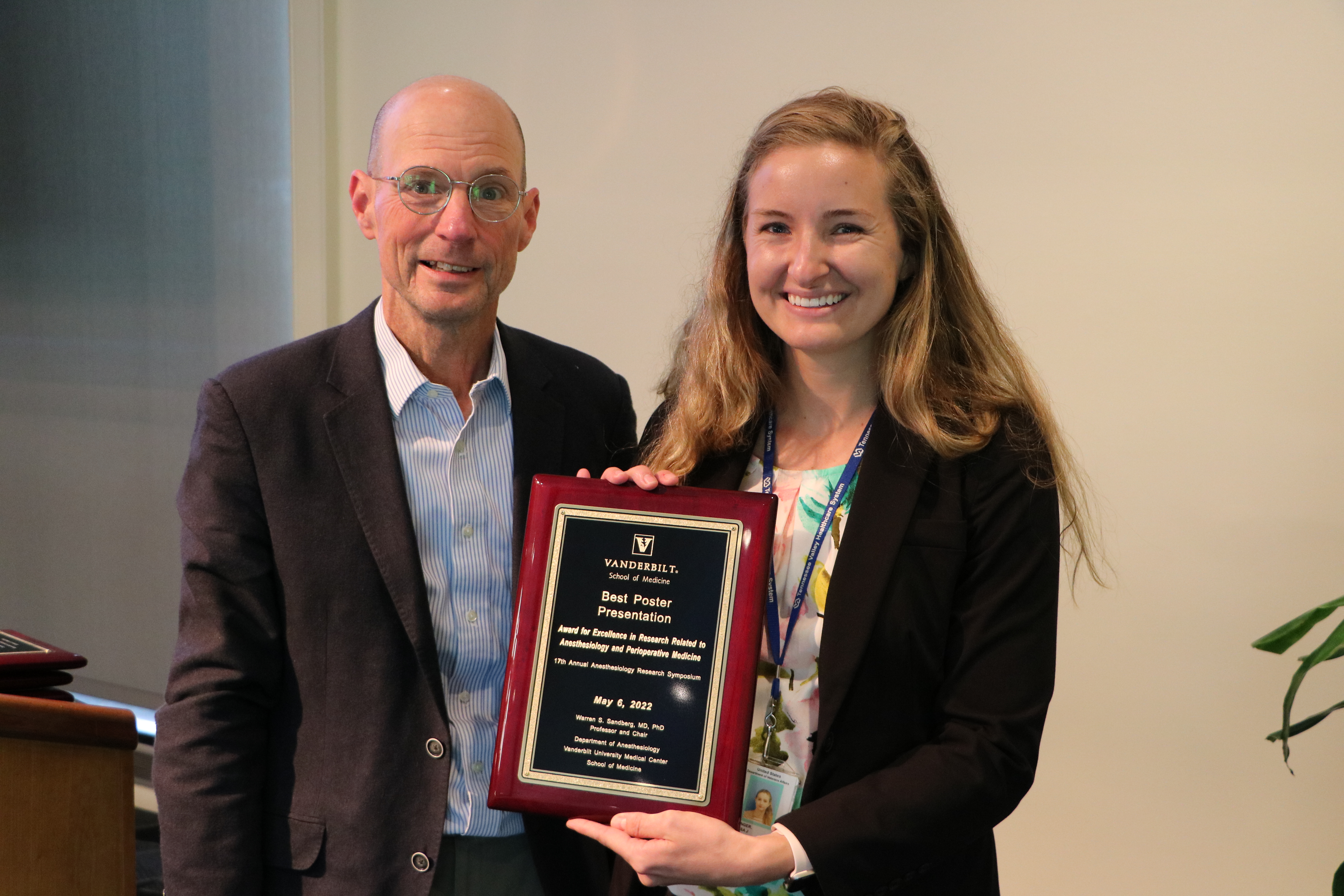 two people holding a plaque