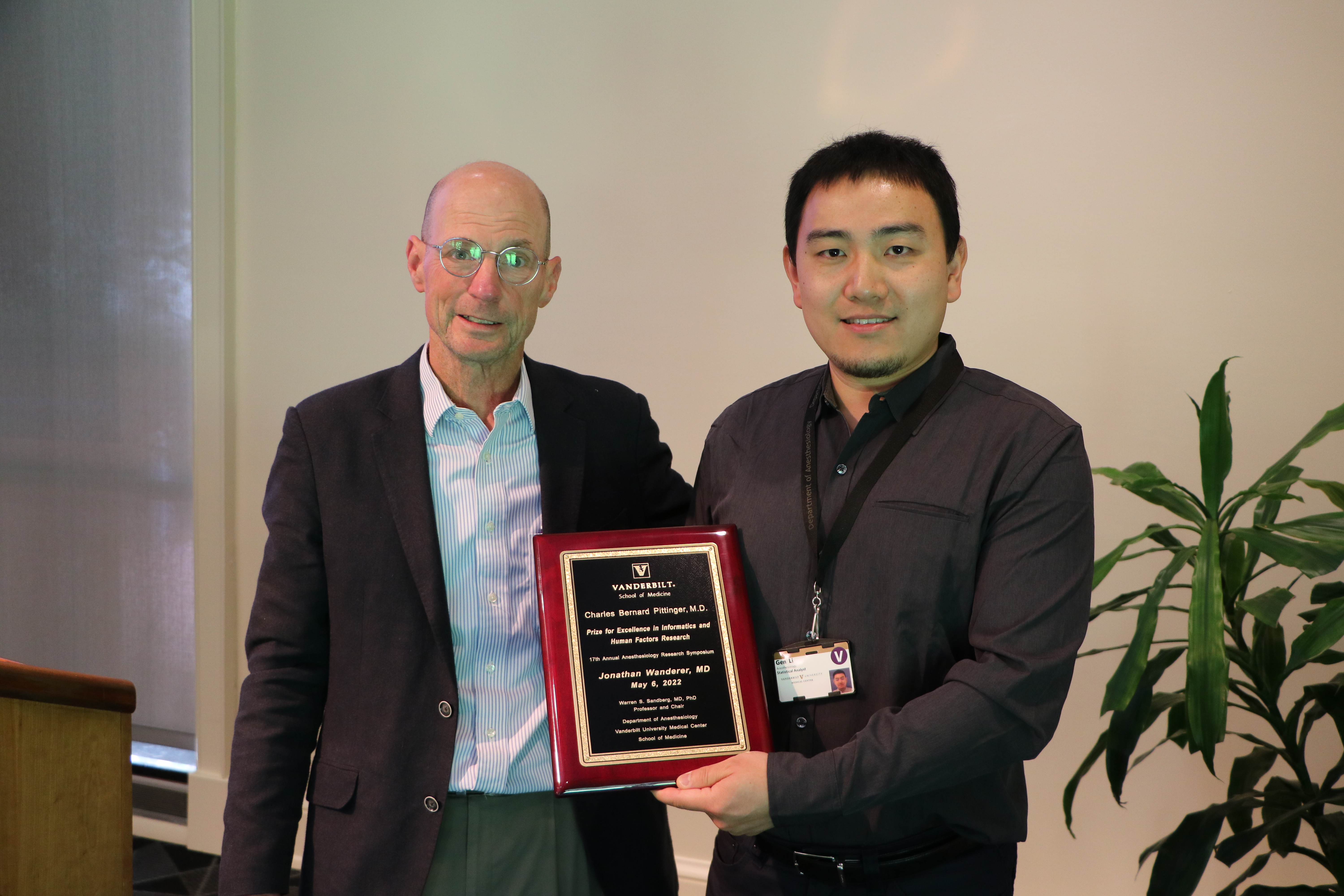 two people holding a plaque