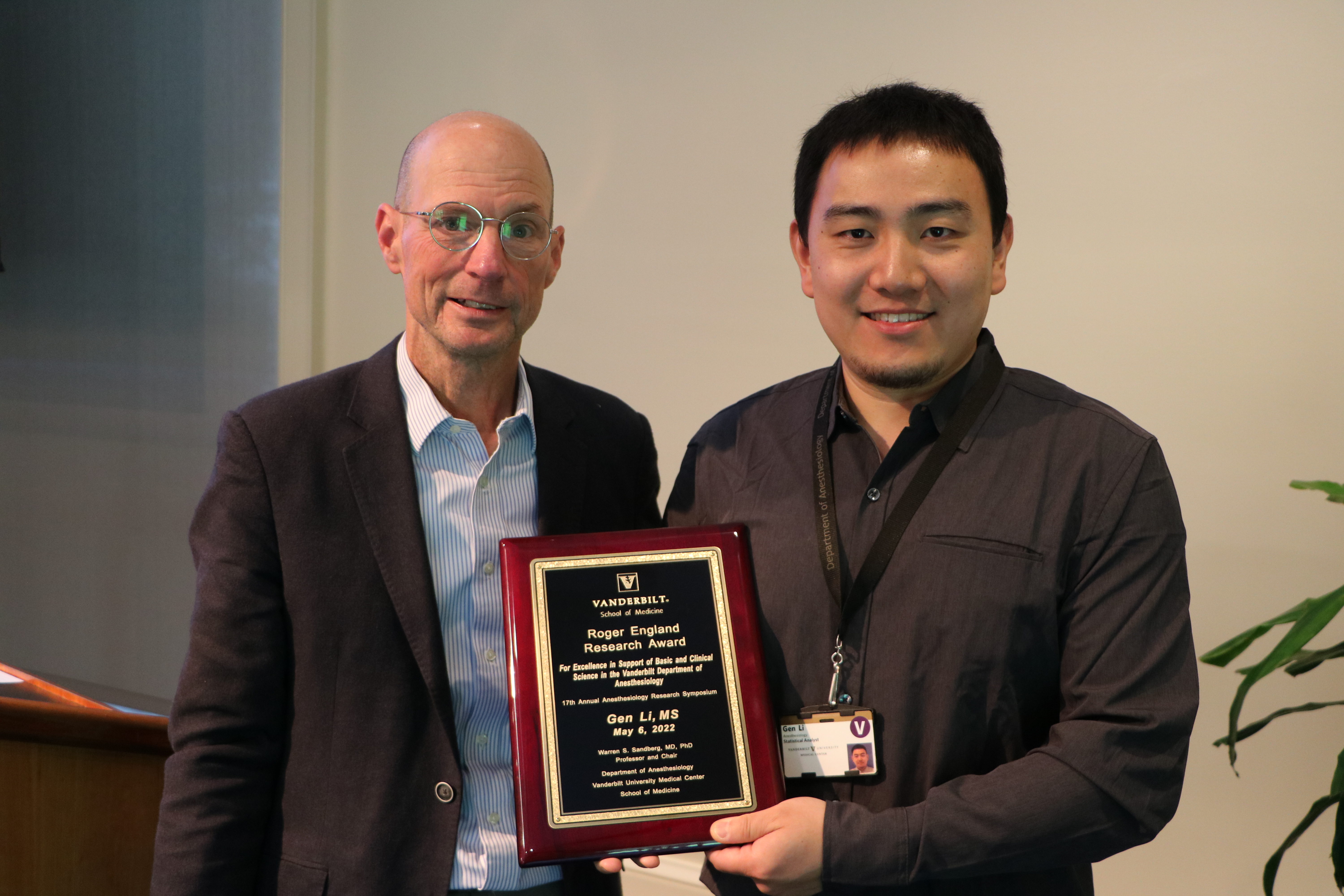 two people holding a plaque