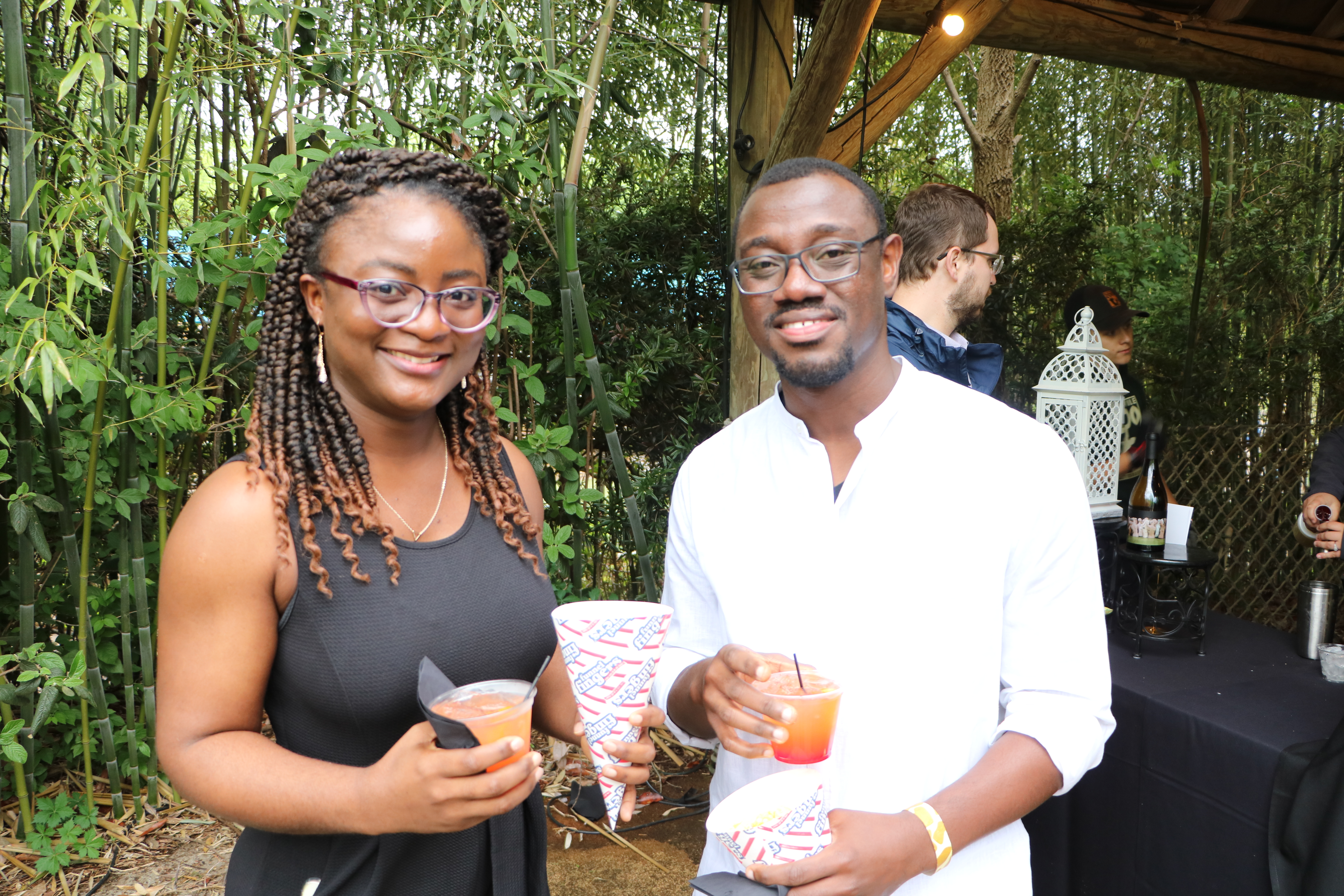 two people holding cocktails and popcorn